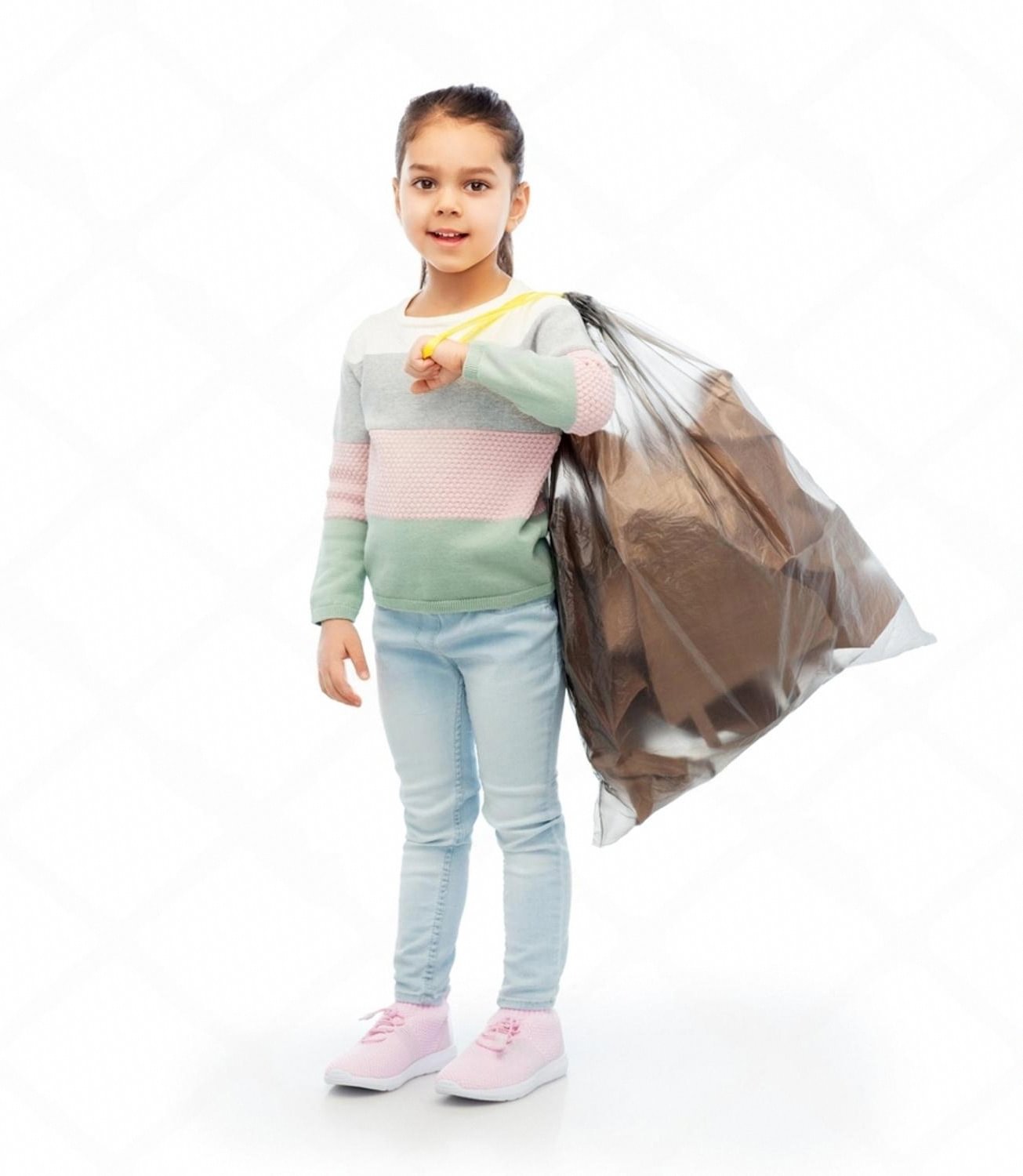 Young pupil carrying a tied waste bag during a school clean-up day